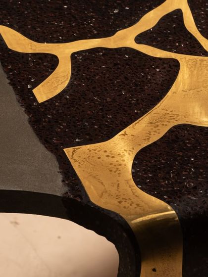 Our coral center table, with its mesmerizing brass inlay and unique concrete shape, is designed for a beautiful art space. The piece is both elegant and unique, a true conversation starter.