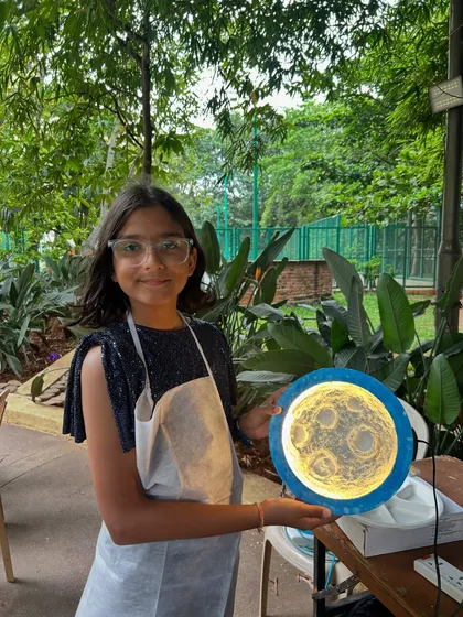 There's nothing more magical than seeing a child's face light up with their own creation. This young artist is so proud of the glowing moon lamp she made at a birthday party workshop.
