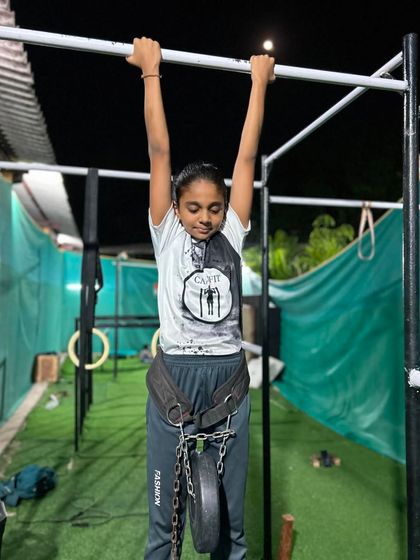 A perfect dead hang with added weight. This exercise is fantastic for building grip strength and decompressing the spine, a staple in our training programs.