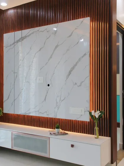We designed this statement TV unit to be a living room's focal point. It features a striking marble-finish panel set against a dark, fluted wood backdrop, with warm ambient backlighting to create a sophisticated atmosphere. The floating console offers clean, modern storage.