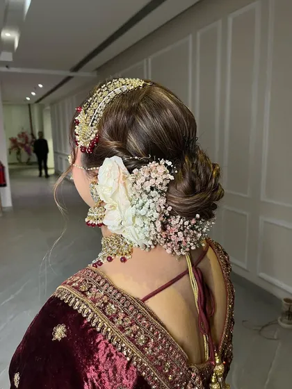 A close up of this intricate floral bun. We combined different types of flowers and baby's breath to create texture and dimension, making this a truly unique bridal hairstyle.