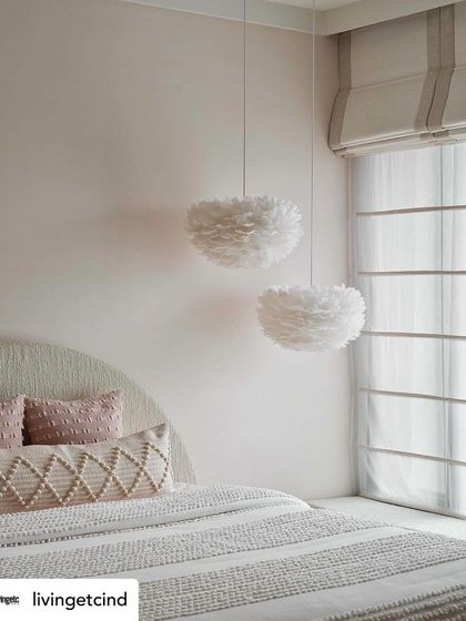 The daughter's bedroom, with its soft pink walls and whimsical feather pendant lights. This image, featured in Livingetc, captures the dreamy and serene quality of the space.