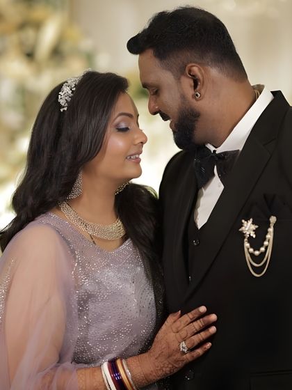 A romantic moment between the couple. The bride's makeup is soft and glamorous, with shimmering eyeshadow and a flawless finish that looks perfect up close.