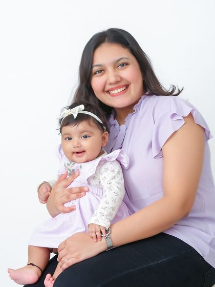 A simple and sweet portrait of a mother and her smiling baby against a clean white background. This classic style ensures the focus remains on their connection.