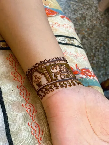 A modern take on groom mehndi. This detailed wristband design features a traditional elephant motif, offering a stylish look that doesn't cover the entire hand. It's perfect for a subtle but meaningful statement.