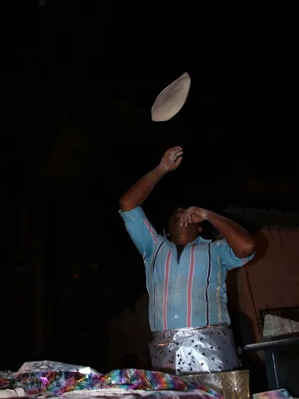 The skill of our chef is on display as he expertly flips a Rumali Roti in the air. This technique makes the bread incredibly thin and soft, a true art form.
