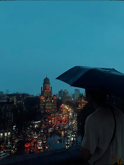 From a high vantage point, I captured this view of a man with an umbrella looking over the traffic-filled streets towards the iconic BMC building. It’s a portrait of a person and the city, showing a moment of pause above the chaos.
