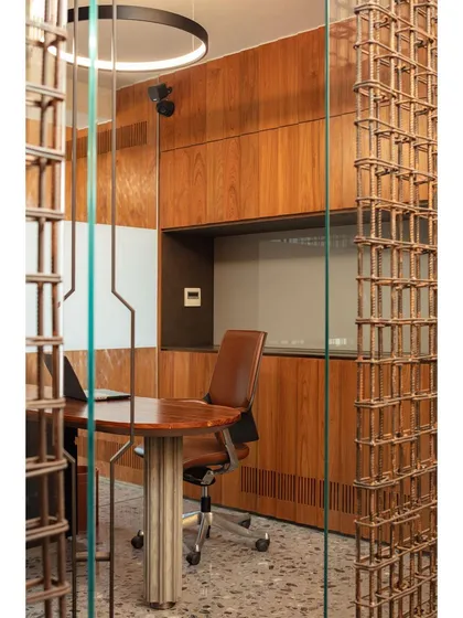 A closer look at the rebar screen partition, showing how the grid-like structure filters light and views while maintaining a sense of openness in the conference room.