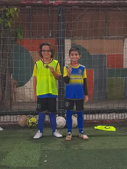 Two players sharing their Player of the Month awards. Teamwork and friendship are key.