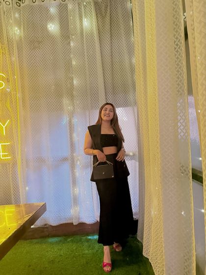 This look is all about confidence. The sleeveless waistcoat adds a layer of sophistication, while the crop top and satin skirt keep it modern and edgy.