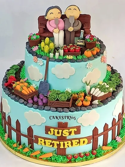 A charming two-tier "Just Retired" cake with a gardening theme. The cake is decorated with a fondant couple on a bench, surrounded by edible vegetables, plants, and a garden fence.