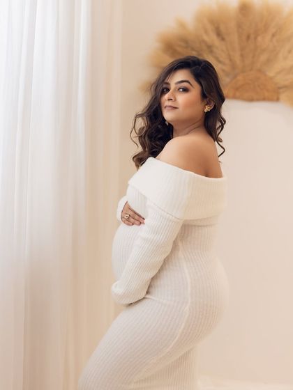 A cozy and chic portrait in a white sweater dress, perfect for a more understated and modern maternity session.
