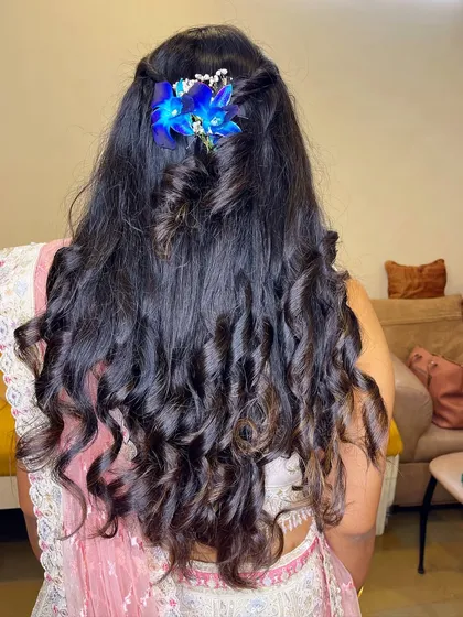 Beautiful soft curls styled on my client's own hair. The blue floral accessory adds a unique and modern touch to the hairstyle.