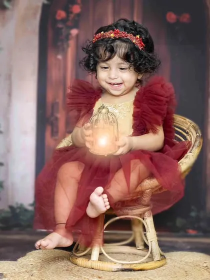 A happy smile from the birthday girl. This shot combines a beautiful setup with her natural charm, creating a perfect first birthday memory.
