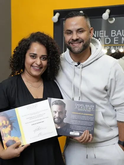 A student proudly holds her certificate and portfolio book, a tangible result of her hard work and creative journey with us.