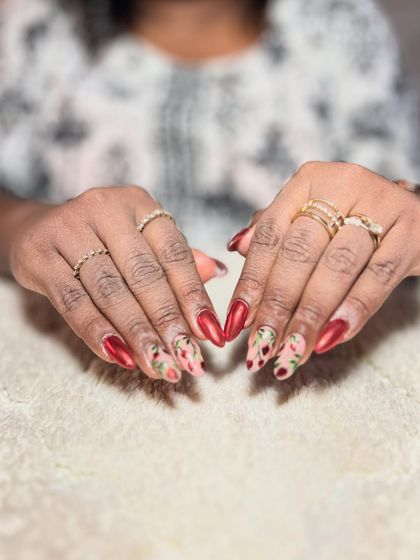 A beautiful red set with floral accent nails. The combination of bold color and delicate pattern is stunning.
