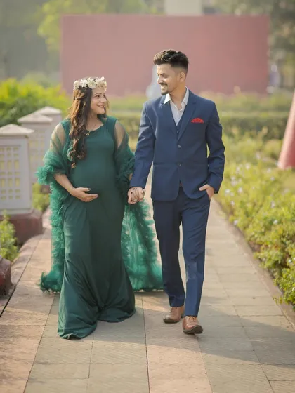 A candid shot of a couple walking and talking, capturing a natural and happy moment during their maternity journey.