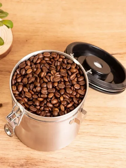 A product shot of coffee beans in a storage canister. This is a clean, bright image perfect for e-commerce websites or product catalogs.