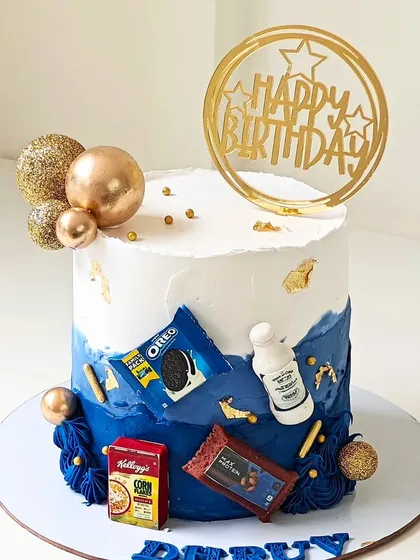 A fun birthday cake for a snack lover, decorated with miniature, edible versions of Oreo, Kellogg's Corn Flakes, and a protein bar.