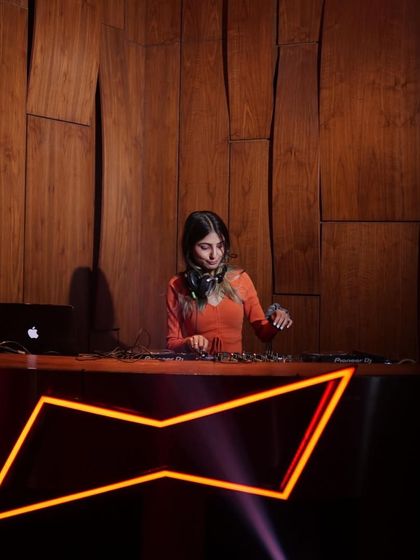 A wider shot of the DJ booth at the Taj, showing the professional setup and branding.