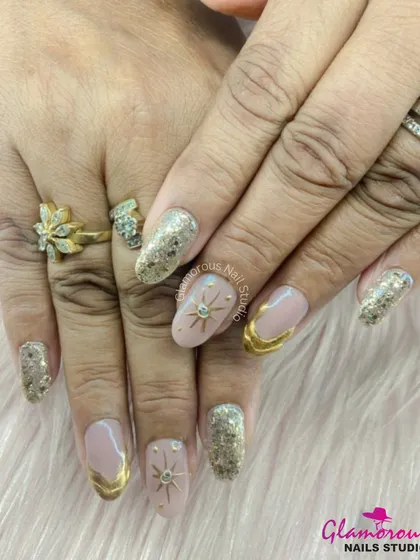 This celestial-themed set is pure luxury. We combined full-coverage gold glitter nails with nude accent nails featuring golden starbursts and swirls. It's a design fit for a queen.