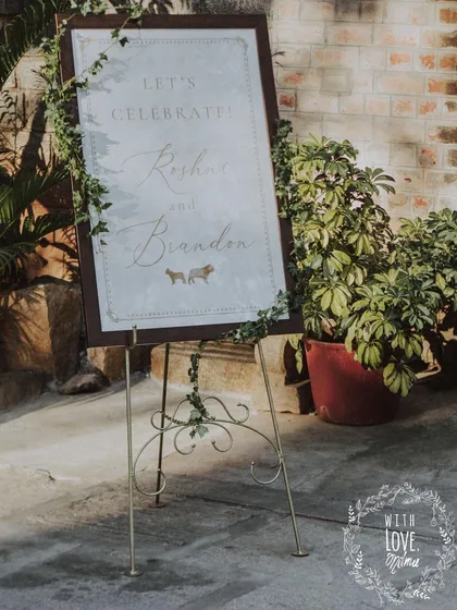 The welcome sign for the 'Love in Ruins' wedding, with elegant calligraphy and a simple ivy border.