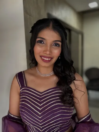 A smiling portrait showing the final look. The makeup is perfect for a party or a pre-wedding event like a sangeet.