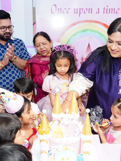 The birthday girl makes a wish on her incredible castle-shaped cake, surrounded by her family and friends. This is the picture-perfect moment every parent dreams of.