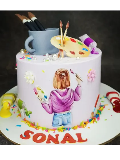 A beautiful cake for an art lover. This fresh whipped cream cake is decorated with an illustration of an artist and edible painting supplies.