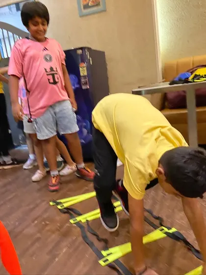 A child works on his coordination with an indoor agility ladder drill. These exercises are fundamental for athletic development and are a core part of our program.