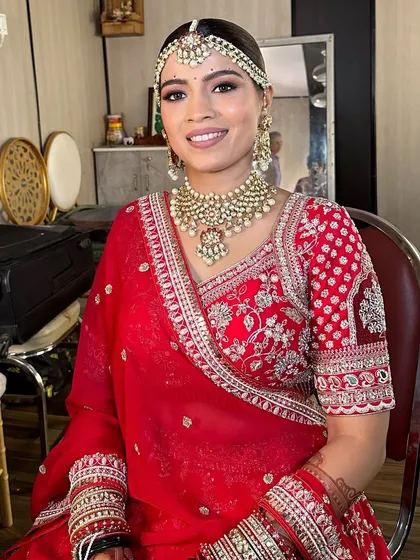 A happy bride seated and ready for her ceremony. The full look, from the neatly draped saree to the glowing makeup, shows a complete and polished bridal styling service.