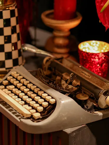 A vintage typewriter detail, surrounded by the warm glow of candles, adds a touch of nostalgia and storytelling to the modern, luxurious setup.