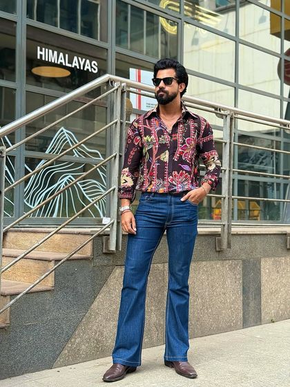 The black floral shirt paired with flared denim jeans for a bold, retro-inspired look. This outfit is all about personality and confidence.