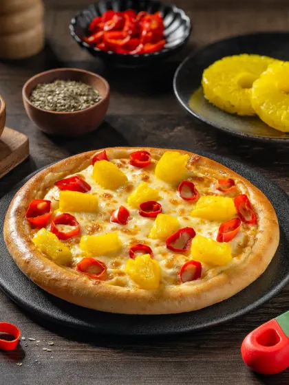 A Hawaiian-style pizza with pineapple and red peppers, a controversial but visually appealing combination.