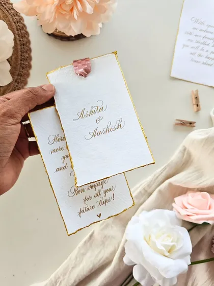 Holding two welcome notes, one with the couple's names and another with a travel wish, "Bon voyage for all your future trips!"