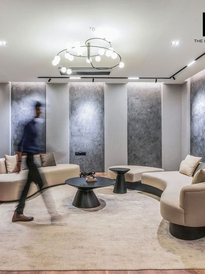 This lounge area within the Embassy office features curved sofas and contemporary lighting, offering a comfortable and stylish space for informal discussions. It shows our versatility in creating different zones within a single office.
