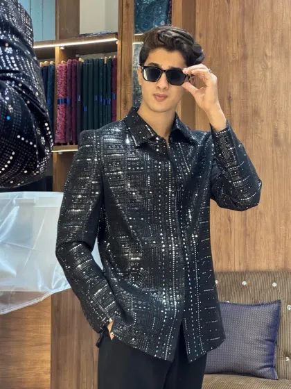 A model posing in a black sequined jacket inside our store. The perfect setting to showcase our party-ready creations.
