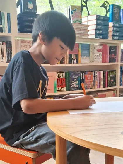 A young bookworm hard at work at our art table. It's a great spot for kids to relax and express themselves after finding a new book.