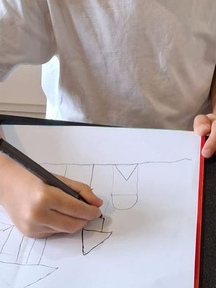 The process begins with simple shapes. Here, a student draws the basic components of a castle, learning about structure and form.