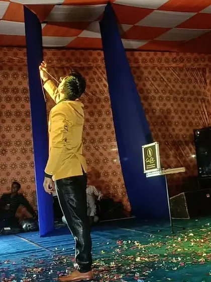 A dramatic pose on stage, using a classic magic prop to create a moment of visual artistry.