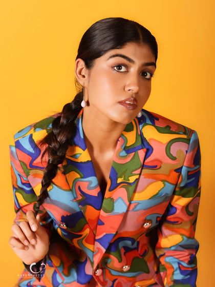 A simple, elegant portrait that lets the colorful suit and the subject's natural beauty shine. The braided hair adds a lovely detail.