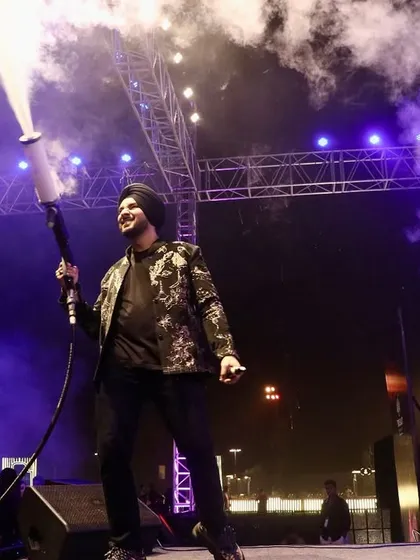 A full-body shot of Gurdeep Mehndi commanding the stage with a CO2 cannon. This image demonstrates our ability to integrate high-impact special effects safely and effectively into a live performance.