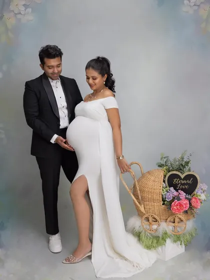 Incorporating props like this beautiful pram adds a whimsical and sweet touch to the couple's maternity portraits.