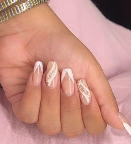 An elegant design featuring a white V-shaped French tip, complemented by accent nails with a delicate swirl of glitter.