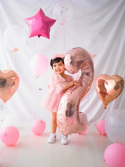 A full-length shot of the birthday girl, looking absolutely adorable in her pink party dress.