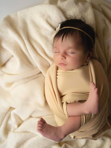 A slightly different angle of this minimalist setup, focusing entirely on the baby's peaceful and curled-up form.