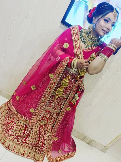 A beautiful bride in a classic red and gold embroidered lehenga. The delicate net dupatta and matching jewellery complete this perfect wedding day look, all available for rent.