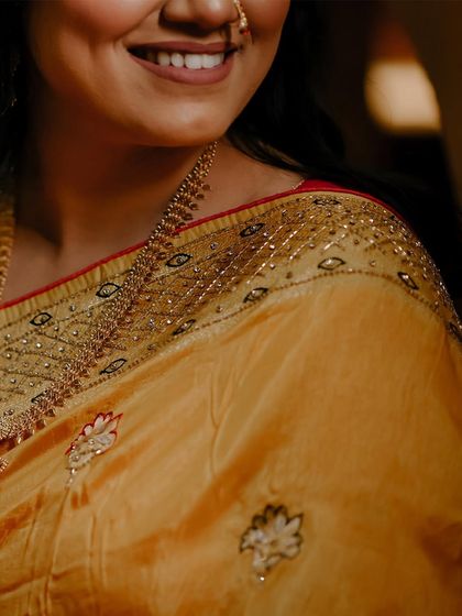 A detail shot of the bride's beautiful yellow and red saree.