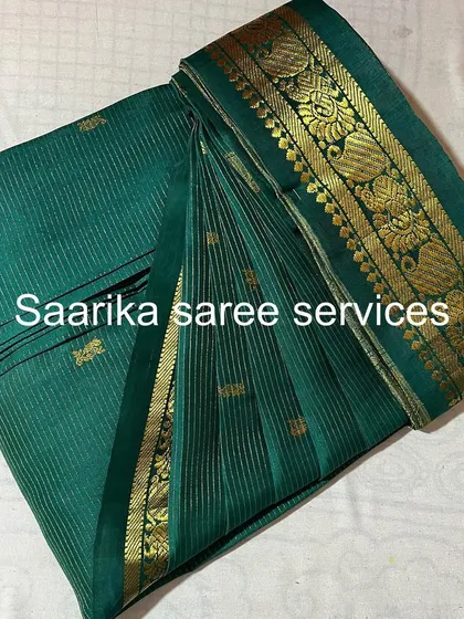 A green saree with gold stripes and butis, folded to perfection.