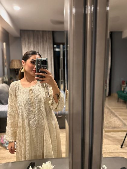A mirror selfie capturing the elegance of the off-white Anarkali. It’s a versatile piece that can be dressed up or down with accessories.